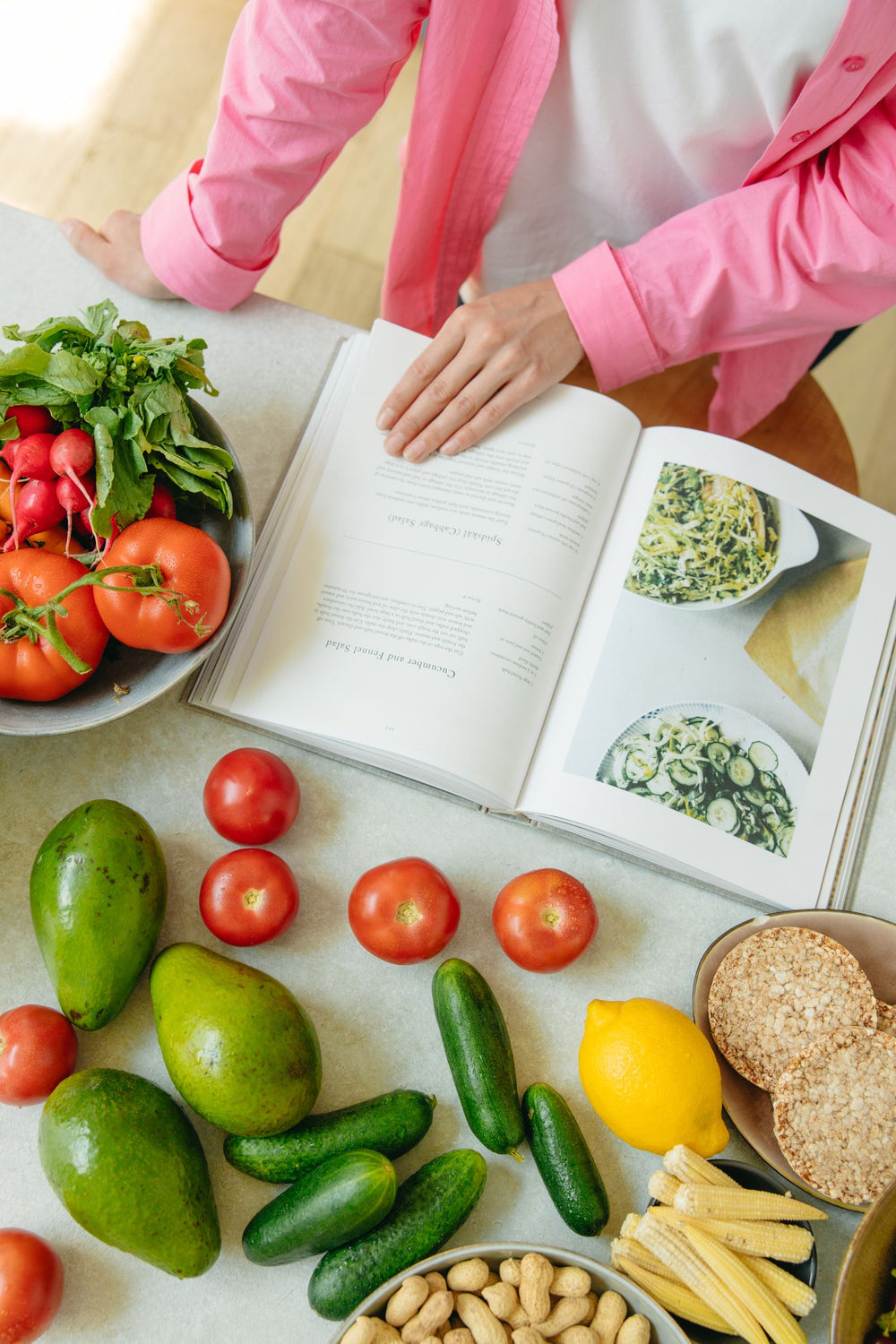 Livre de recettes ouvert sur un plan de travail entouré de légumes frais